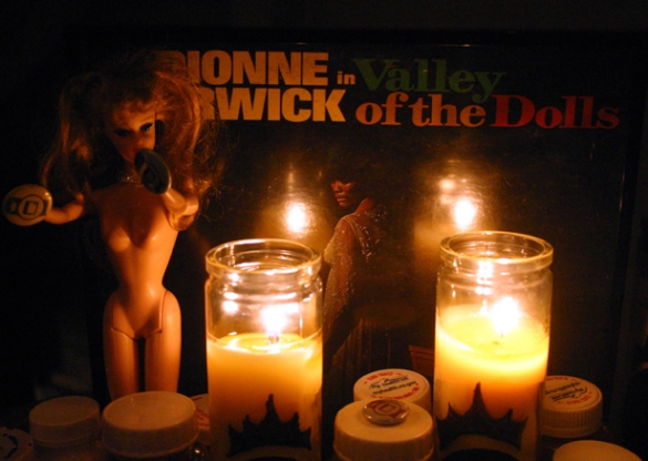 Naked barbie doll, Dionne Warrick album and candles.